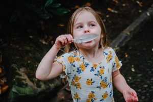 girl plays with feather