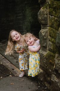 sisters peep around a wall