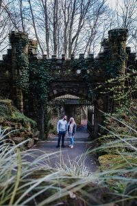 portrait image of engaged couple near castle gates