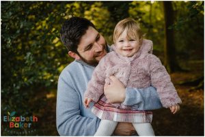 baby girl and dad laughing at something beyond the camera
