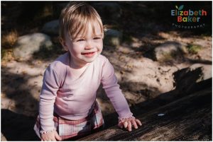 baby trying to walk looks into the sun with shadows on the ground