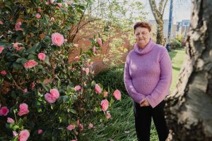 A lasy stand near pink flowers telling her story about giving up smoking