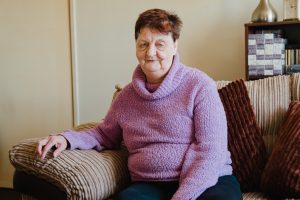 Lady sitting on the sofa she bought with the money saved through giving up smoking