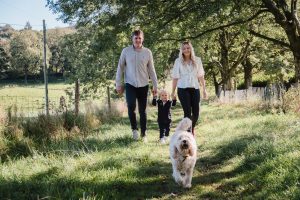 family walking towards camera with dog in foreground