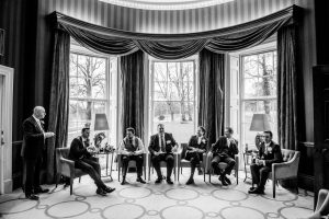 black and white photo of all the groomsmen in the window