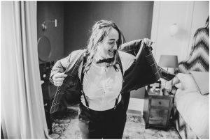 bride putting her jacket on black and white image