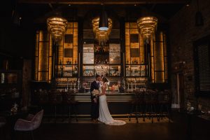 couple kissing in front of the bar at Manor HOuse