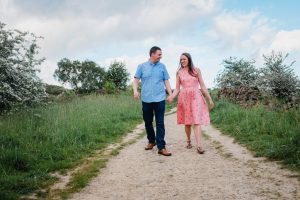 engaged couple walking towards camera