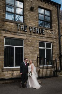 couple stand under the sign at the venue bowers mill