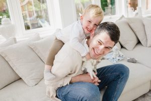 little boy jumping on his dad's back playing