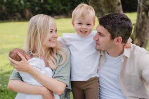 little boy looking at the camera whilst his parents look at him