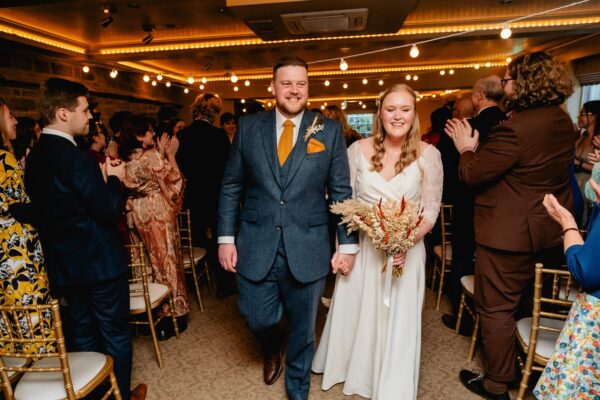 bride and groom walk back down the aisle after the ceremony at whitley hall Sheffield
