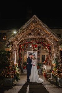Christmas decorations at Whitley Hall with bride and groom in the doorway of the Hall backlit and festive