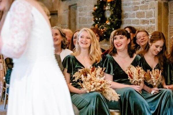 bridesmaids looking on as the bride and groom during their vows