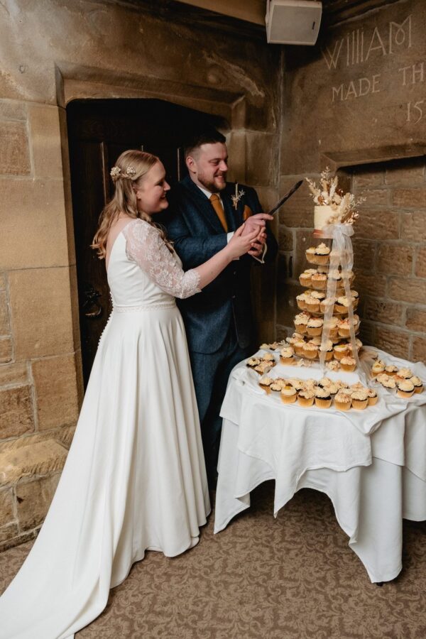 the bride and groom cut the cake, portrait photo in colour