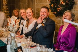 Guest react to speeches given by the best man who is off camera