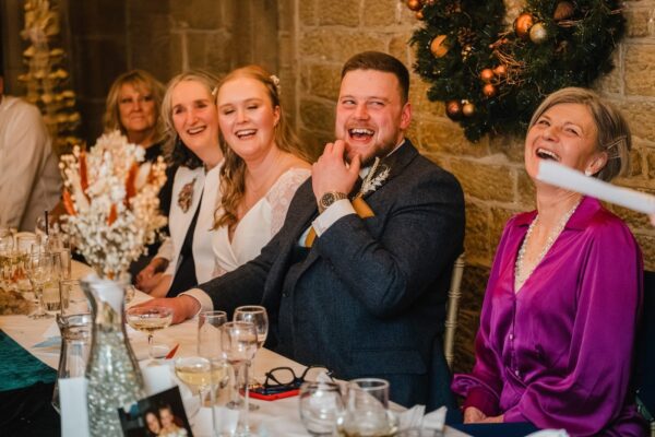 Guest react to speeches given by the best man who is off camera