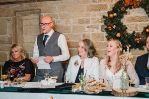 father of the bride gives a speech showing the top table at the wedding