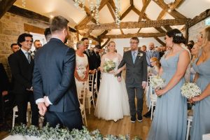 bride and her dad walk down the aisle to meet the groom