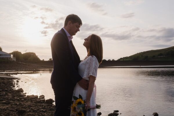 wedding couple romantic photo by a lake at sunset
