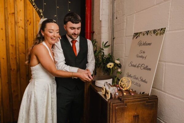 bride and groom cutting the cake in Sheffield at Yellow Arch Studios